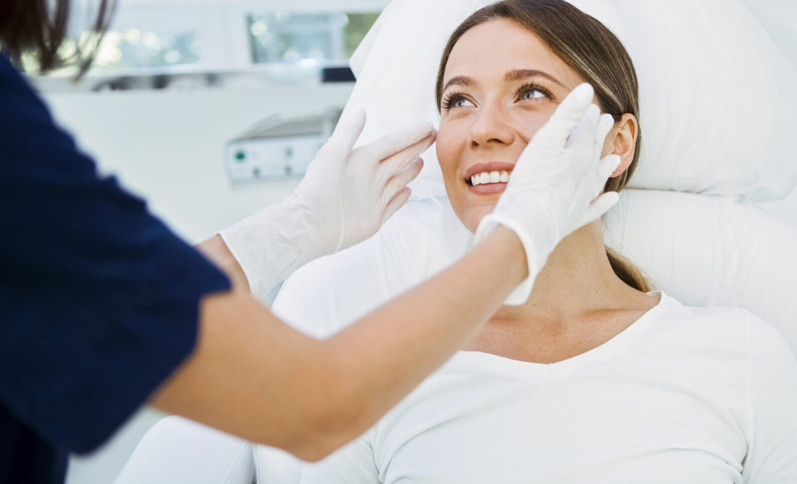 Cosmetologist preparing to doing cosmetic facial treatments for the young woman