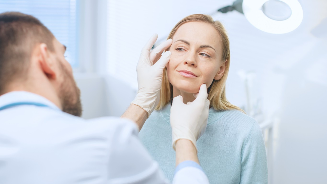 Plastic / Cosmetic Surgeon Examines Beautiful Woman's Face, Touches it with Gloved Hands, Inspecting Healed Face after Plastic Surgery with Amazing Results.